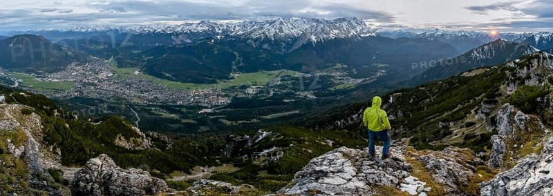 View Mountain panorama with Wetterstein mountains and Zugspitze, at sunset with sun star, mountaineer at the summit of the Kramerspitz, in autumn, Ammergau Alps, in autumn, Bavarian Prealps, Bavaria, Germany