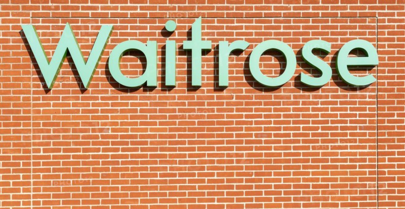 Waitrose shop sign on brick wall, UK