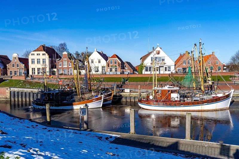 The fishing village of Greetsiel, historic fishing harbour, with the largest shrimp cutter fleet in East Frisia, historic houses, winter, partly frozen, in Lower Saxony, Germany