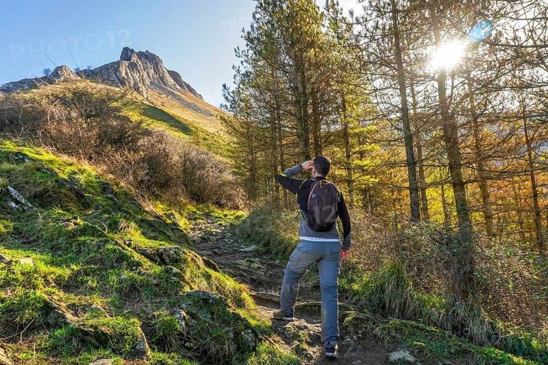 Male hiker admiring the landscape while trekking through mount txindoki in gipuzkoa, basque country, on a sunny day