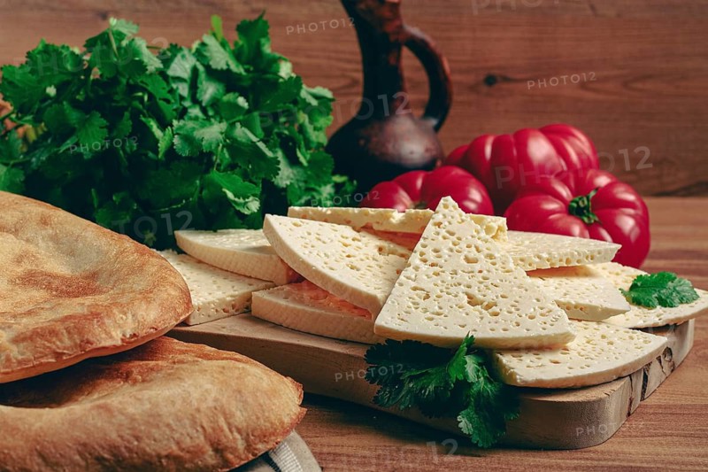 Georgian sliced cheese, on a wooden chopping board, with tomatoes with herbs and lavash, rustic style, Georgian cuisine, no people