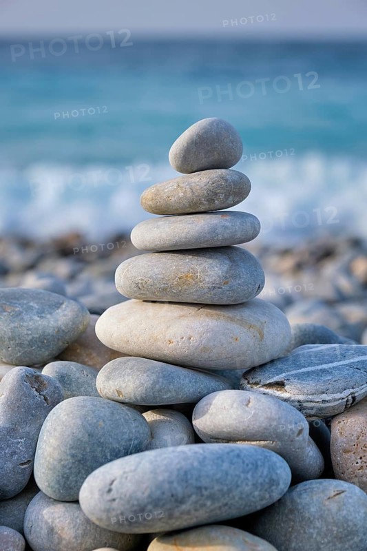 Zen meditation relaxation concept background, balanced stones stack close up on sea beach