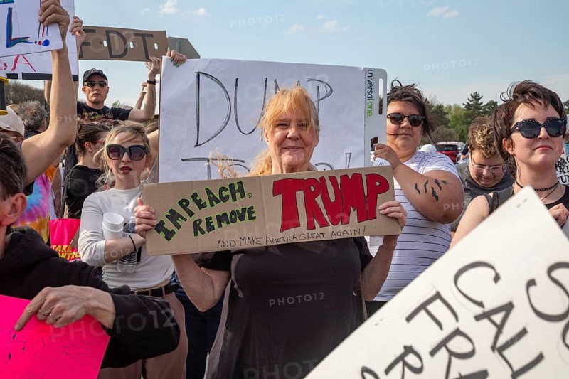 Warren, Michigan USA - 29 April 2025 - Thousands of protesters showed up to 'unwelcome' President Donald Trump who celebrated his first 100 days in office with a rally at Macomb Community College. The protesters cited government funding cuts which have cost jobs, health care, retirement, and more