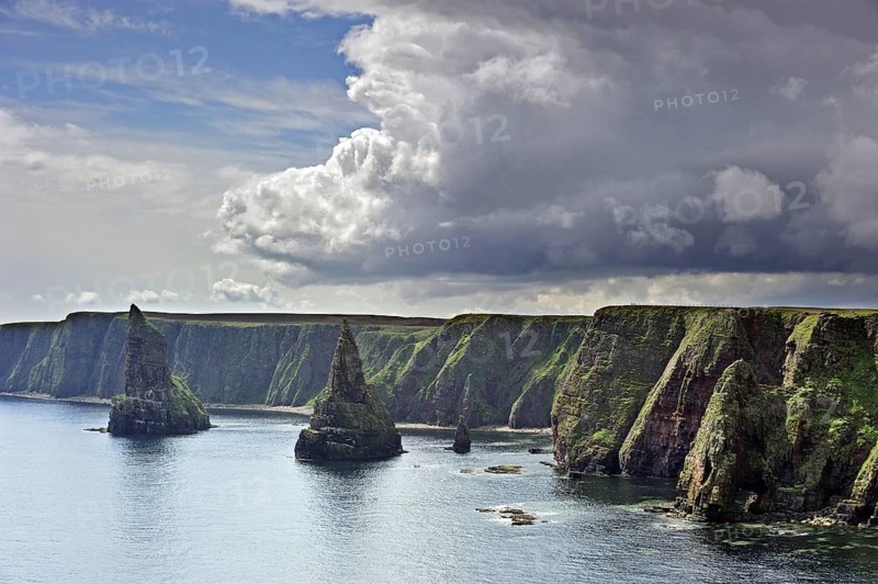 Rain clouds over the sea cliffs and stacks of Duncansby, Caithness, Highlands, Scotland, UK