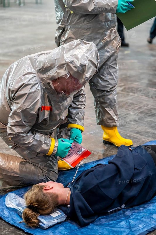 Viewing of patients in front of decontamination of injured persons after an assumed accident with hazardous substances, patient is intubated and ventilated by hand, fire brigade and aid organisations practise setting up and operating a decontamination station, injured persons are viewed and then washed in a special shower tent to remove possible hazardous substances and chemicals in order to avoid further injuries, the emergency services wear special, ventilated protective suits, large-scale exercise by the Essen fire brigade
