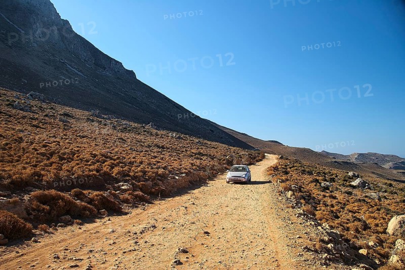 Driveway, single car, morning light, Machia, rock face, Gramvoussa peninsula, Pirate Bay, Balos, Tigani, blue cloudless sky, West Crete, island of Crete, Greece