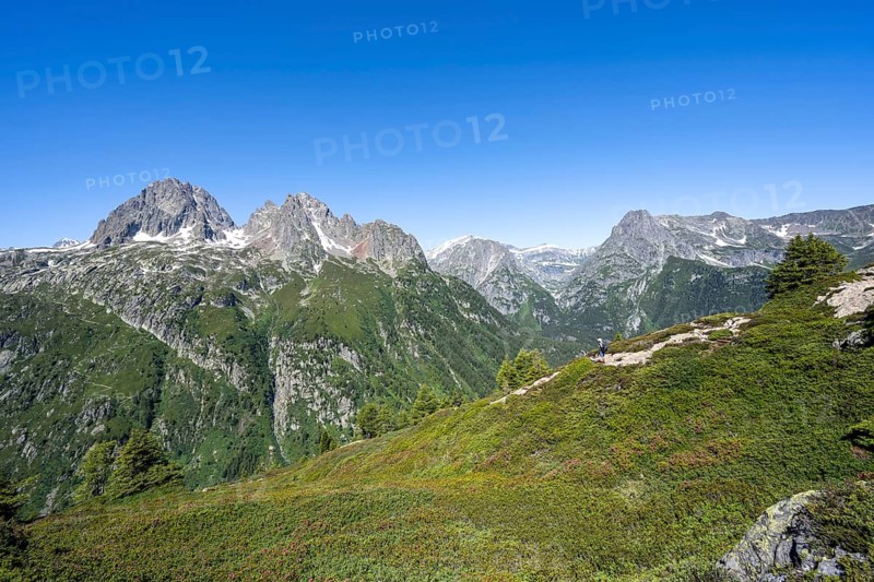 Mountaineer on hiking trail to Aiguillette des Posettes, mountain panorama with summit Aiguille de Mesure and Aiguille de Chamois, Mont Bues and Pointe de la Terasse, Chablais Alps, Chamonix, Haute-Savoie, France