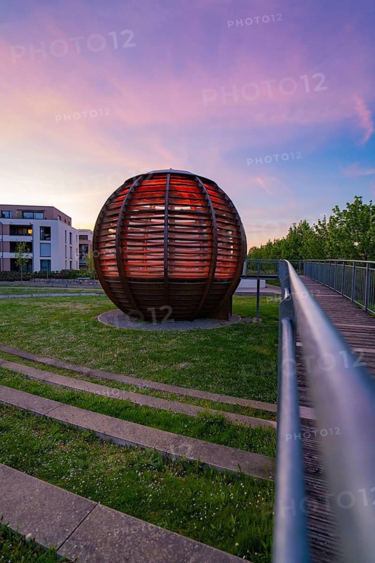 Spherical wooden building at sunset, modern style, sky in shades of red and purple with building in the background, Forstkugel, Nagold Black Forest, Germany