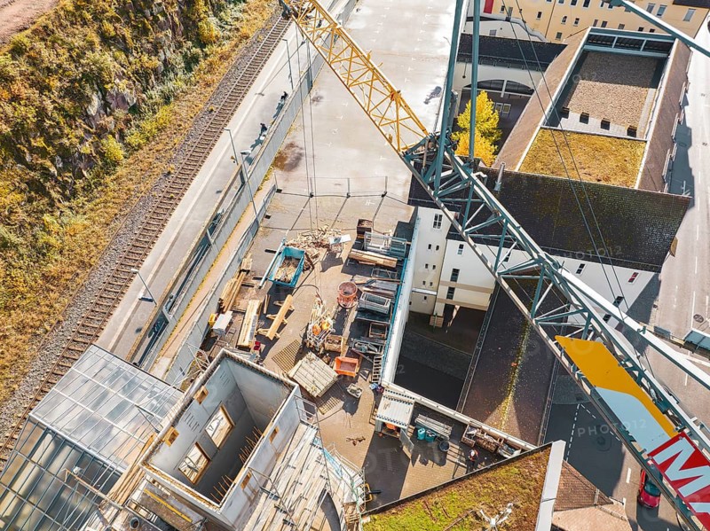 Top view of a crane construction site with equipment and buildings in an urban area, ZOB Calw reconstruction for Hermann Hessebahn, Calw, Black Forest, Germany