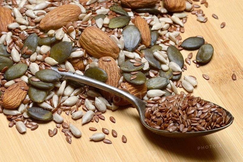Seeds in spoons, mix of almond seeds, sunflower seeds, linseeds and pumpkin seeds