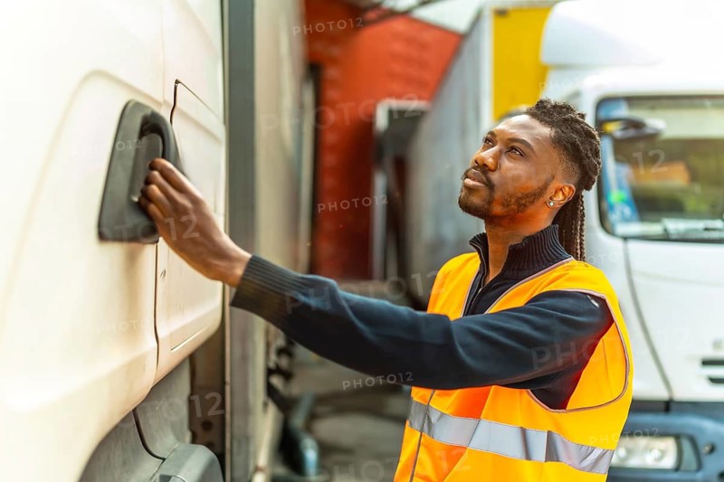 Side view of an African driver opening the door of the truck