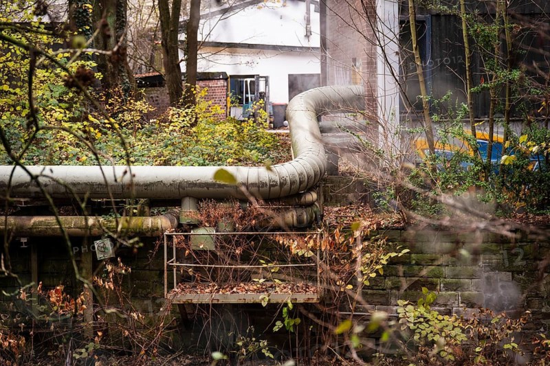 District heating pipeline in front of old industrial buildings on the banks of the Wupper, Wuppertal, Germany
