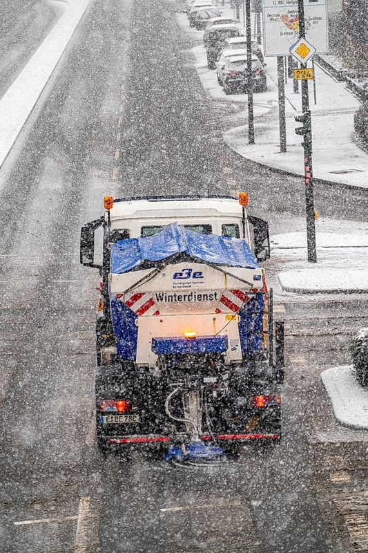 Winter weather, heavy snowfall, city centre traffic, winter service vehicle from Entsorgungsbetriebe Essen in action on Alfredstraße, B224, gritting and clearing snow, North Rhine-Westphalia, Germany