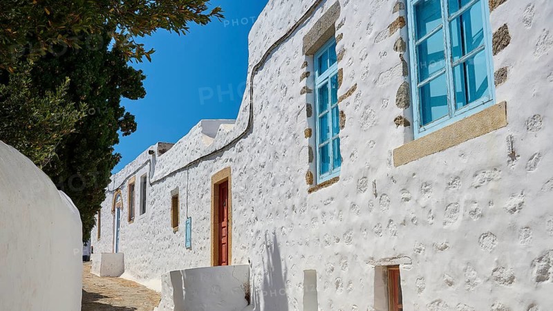 Row of white houses with blue windows under a blue sky, traditional Greek architecture, Chora, Old Town, Patmos, Dodecanese, Greek Islands, Greece