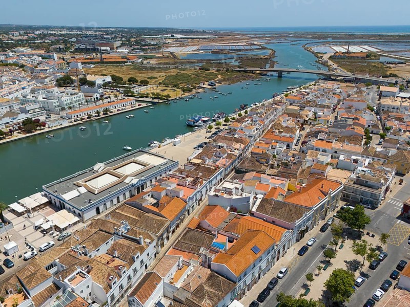 Town with numerous orange-coloured roofs along a river in summer weather, aerial view, Tavira, Faro, Algarve, Portugal