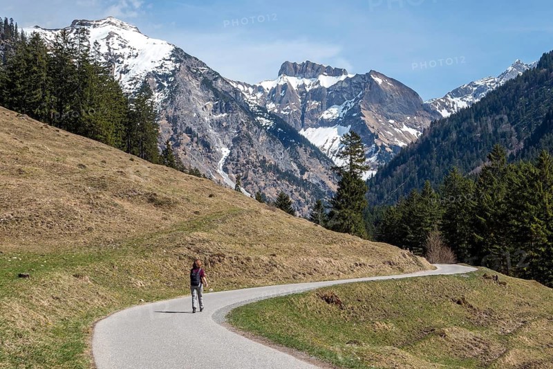 Female hiker on the Oytalstraße from Oberstdorf to Oytal with a view of Oytal behind Kratzer and mountains of the Allgäu Alps, Oberstdorf, Oberallgäu, Bavaria, Germany