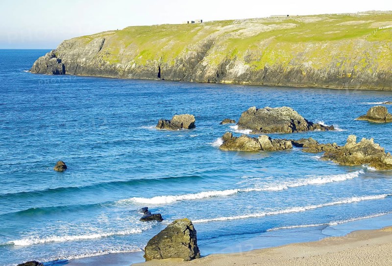 Picturesque coast with smooth-washed stones and deep blue sea under clear skies, Durness, Highlands, Scotland, Great Britain