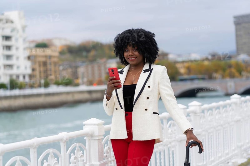 Portrait with copy space of an elegant african american businesswoman using phone next to an urban river