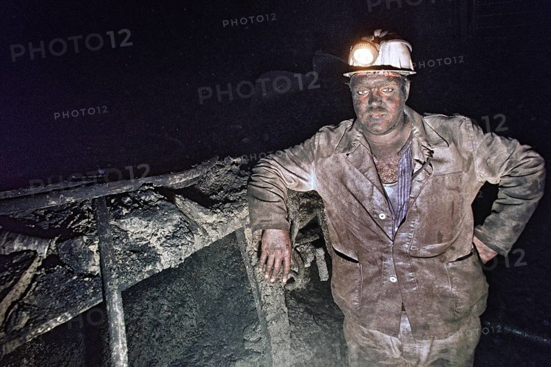 Herten, DEU, 31.03.1995 - Miner at Ruhrkohle Ewald works underground in coal seam. The mine was discontinued in 2000, Herten, Germany