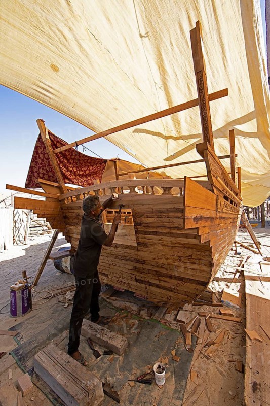 Indian man working at a dhow shipyard in Sur, Janub ash-Sharqiyya province, Oman