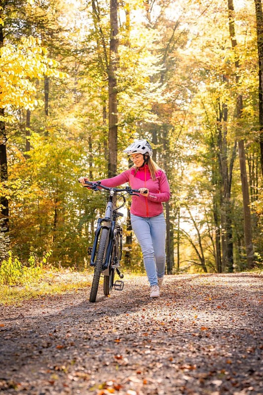 Woman with Ebike through autumn forest, Black Forest, Gechingen, Germany