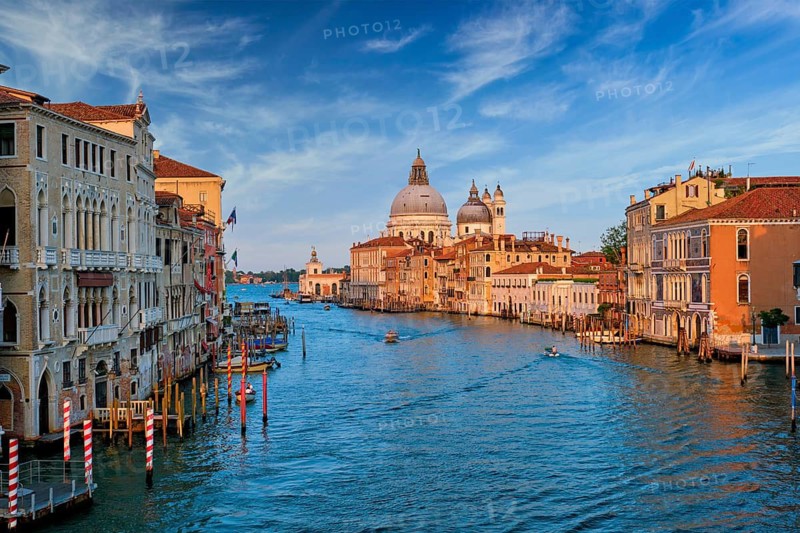 View of Venice Grand Canal with boats and Santa Maria della Salute church on sunset from Ponte dell'Accademia bridge. Venice, Italy