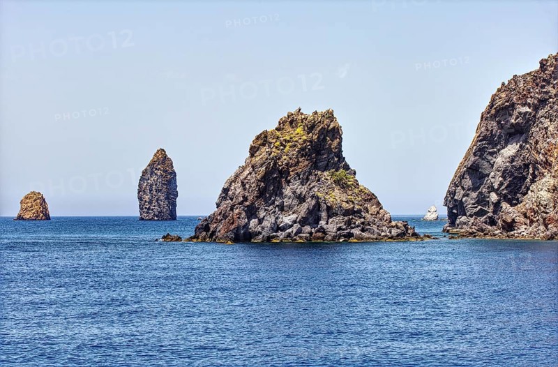 Rocky islands rise majestically from the calm sea under glowing sky, Lipari Lipari Islands, Sicily Italy