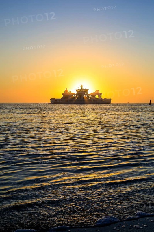 Ferry and sunset on the west coast of Norderney, Lower Saxony, Germany