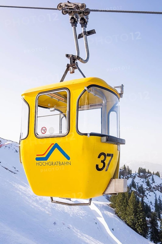Yellow Hochgrat cable car over snow-covered mountains under blue skies, Hochgrat Mountains, Allgäu Alps, Oberreute, Germany