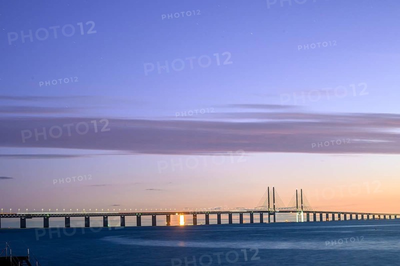 Modern Øresund bridge across the sea at sunset with colorful sky illuminated by a colorful sunset, Malmö, Skane län, Sweden