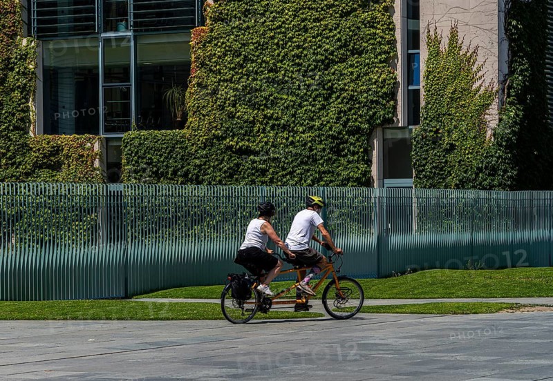 Tourists on bicycles, fence at the Federal Chancellery, Berlin, Germany