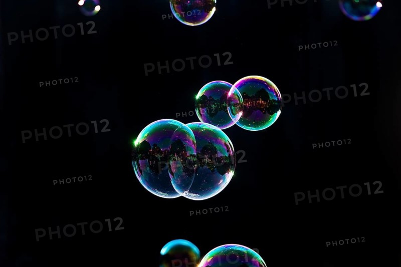 Iridescent soap bubbles in the colours of the rainbow against a black background, Recklinghausen, North Rhine-Westphalia, Germany