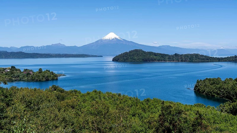 Osorno volcano with snow-capped peak, view over Lake Llanquihue with forested islands in the foreground, Los Lagos Region, Chile