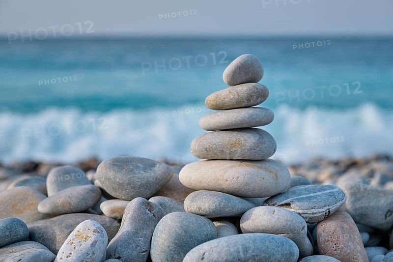 Zen meditation relaxation concept background, balanced stones stack close up on sea beach
