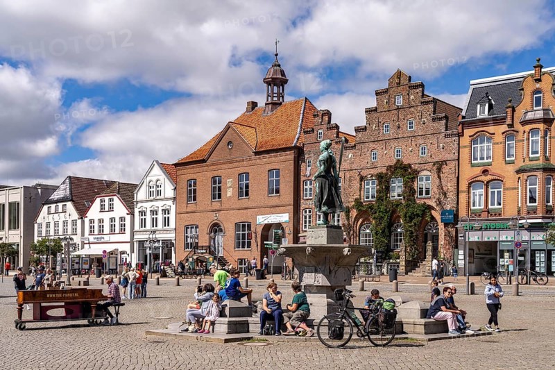 Tine statue of the Asmussen-Woldsen monument or Tine fountain in front of the houses of the old town centre on the market square in Husum, North Friesland district, Schleswig-Holstein, Germany