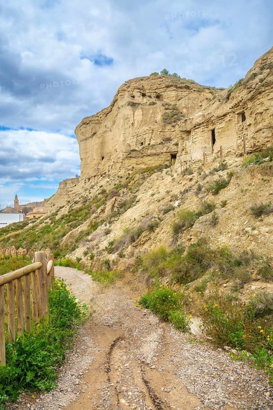 Pathway leading to the historical arguedas caves nestled in the rocky landscape of navarre, spain, showcasing a blend of nature and history