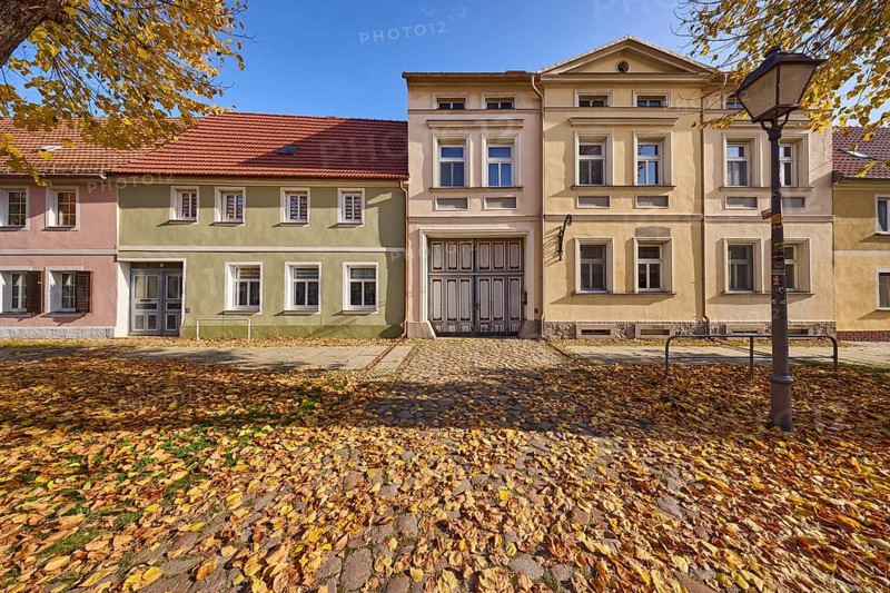 Cobbled street, residential building with lantern, foliage and autumn trees, blue sky, Lindenstraße, Mühlberg Elbe, Elbe-Elster district, Brandenburg, Germany