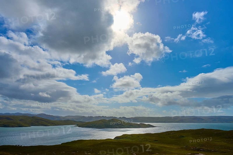 The sun shines through the clouds over a calm body of water, Loch Torridon, Balgy, Strathcarron, Scotland, United Kingdom, Great Britain