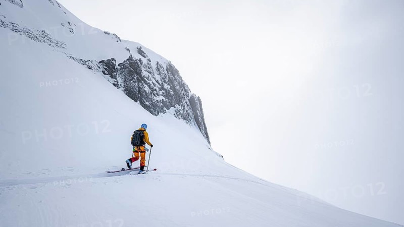 Lone ski tourer in snowy mountain landscape in the morning light, ascent to the Wildhorn, cloudy mood, high tour, Bernese Alps, Bernese Oberland, Switzerland