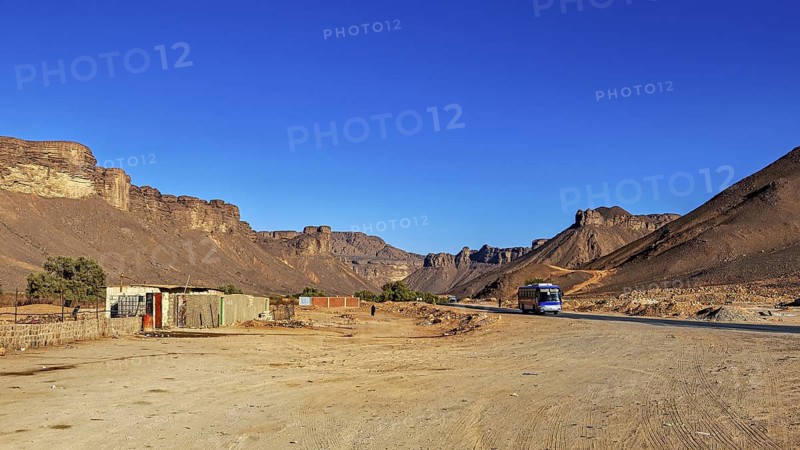 Lonely village in a vast desert landscape with steep rock formations, settlement in the Sahara in Algeria