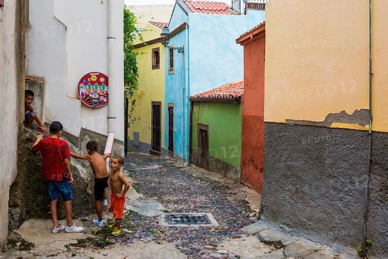 Children playing and colourful houses, Bosa, district of Oristano, Sardinia, Italy
