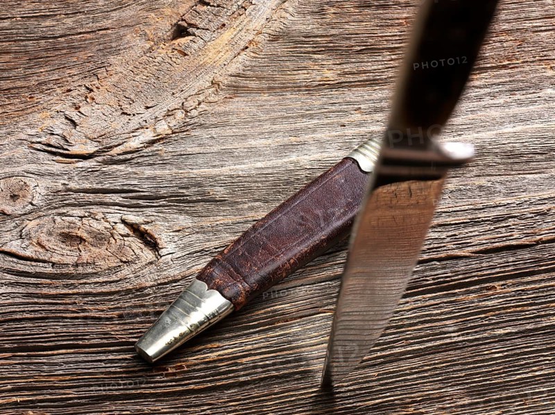 Knife stuck in weathered wood