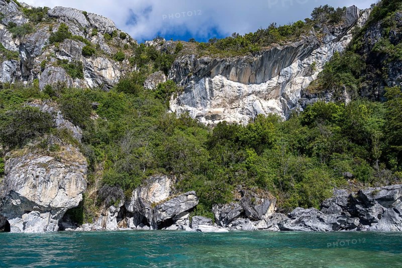 Marble rocks with overgrown rock walls on the turquoise waters of Lake General Carrera, Capillas de Mármol, Aysén Region, Chile