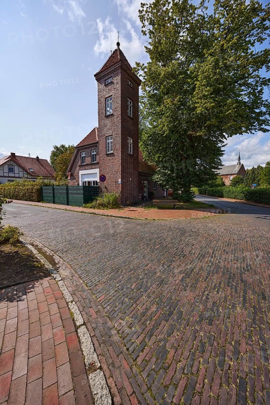 Historic fire station, hose tower, brick building, tree, historic village centre, intersection of Westerende and Dammstraße, Zetel, district of Friesland, Lower Saxony, Germany