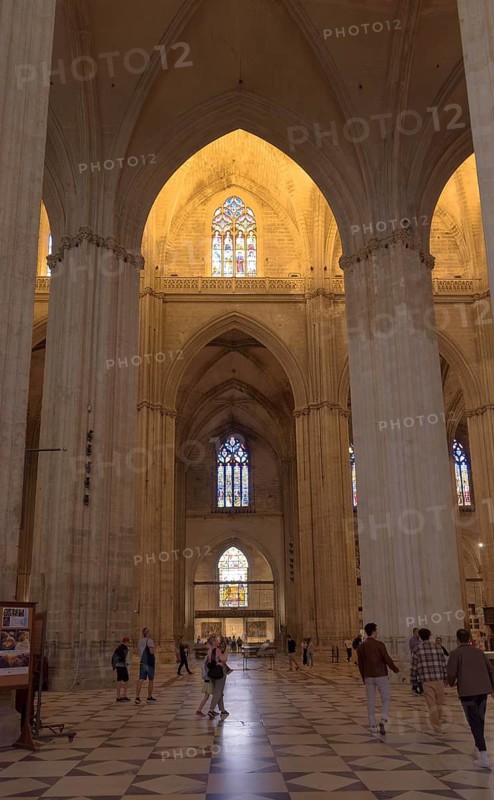 Extensive church interior with high vaults and illuminated windows, Seville, Andalusia, Spain