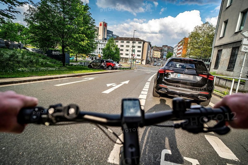 Cycling in the city, city centre road, car blocking cycle lane traffic in both directions, cyclist perspective, Essen, North Rhine-Westphalia, Germany