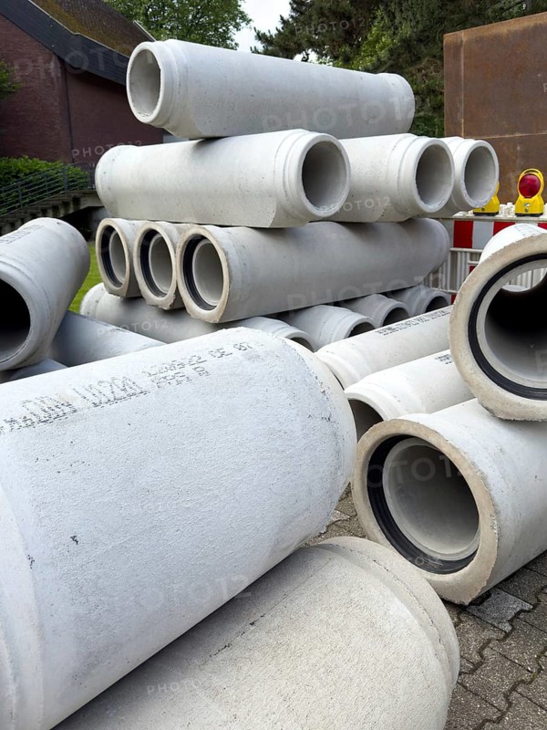 Several many stacked concrete pipes stored at the roadside Concrete pipes for sewer construction Laying of sewer during road construction, Germany