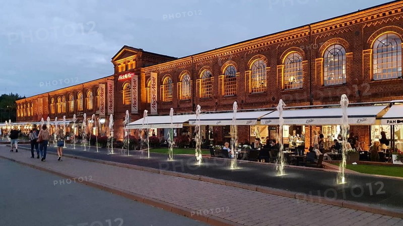 Lively red brick façade with evening lighting and fountain, Manufaktura, Lódz, Lodz, Poland