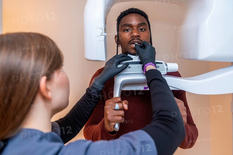 Dental professional preparing a patient for an x ray scan, ensuring precise positioning for a comprehensive dental examination