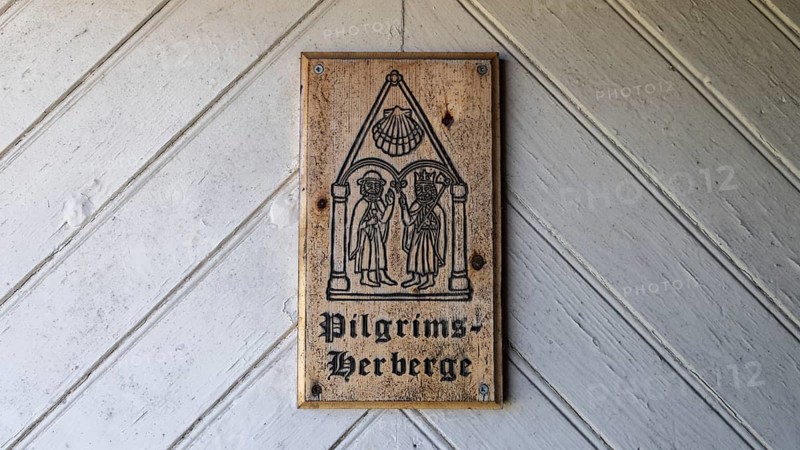 Wooden plaque with medieval drawing and the words 'Pilgrims Hostel' on a wooden door, Arteid Vestre Gård, Norway